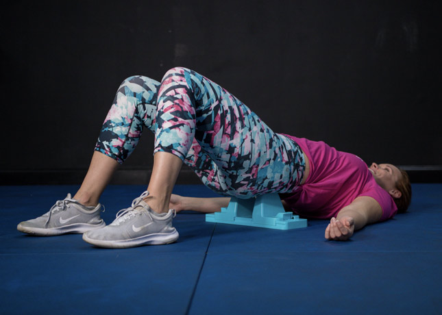 A woman athlete in the gym demonstrating the use of the Psoas tool